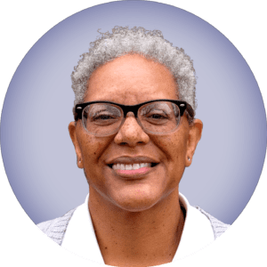 Pamela Singleton, headshot of a black woman with short grey hair, wearing glasses and smiling